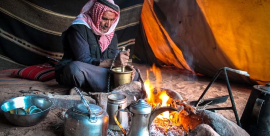 Bedouin man in Wadi Rum grinding coffee - Jordan tour